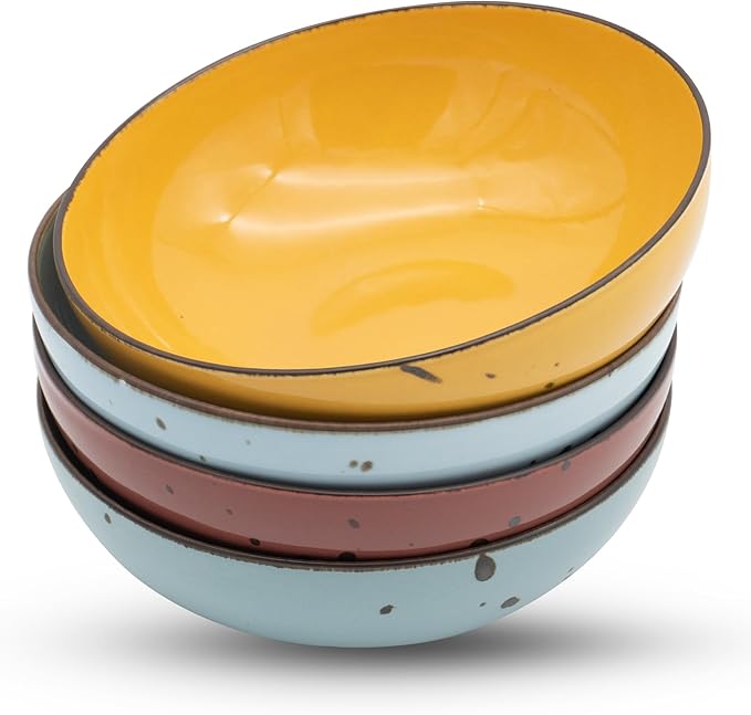 Four boldly colored round porcelain bowls on a bright kitchen countertop